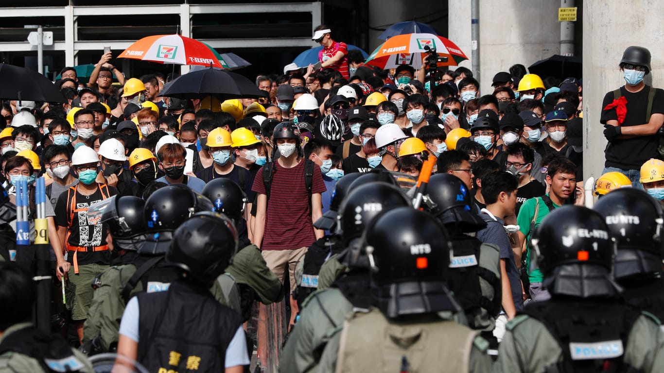 Polizisten stehen Demonstranten im Bezirk Yuen Long gegenüber: Tausende Menschen protestierten gegen die Regierung und einen Angriff von Schlägertrupps.