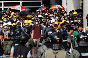 Polizisten stehen Demonstranten im Bezirk Yuen Long gegenüber: Tausende Menschen protestierten gegen die Regierung und einen Angriff von Schlägertrupps.