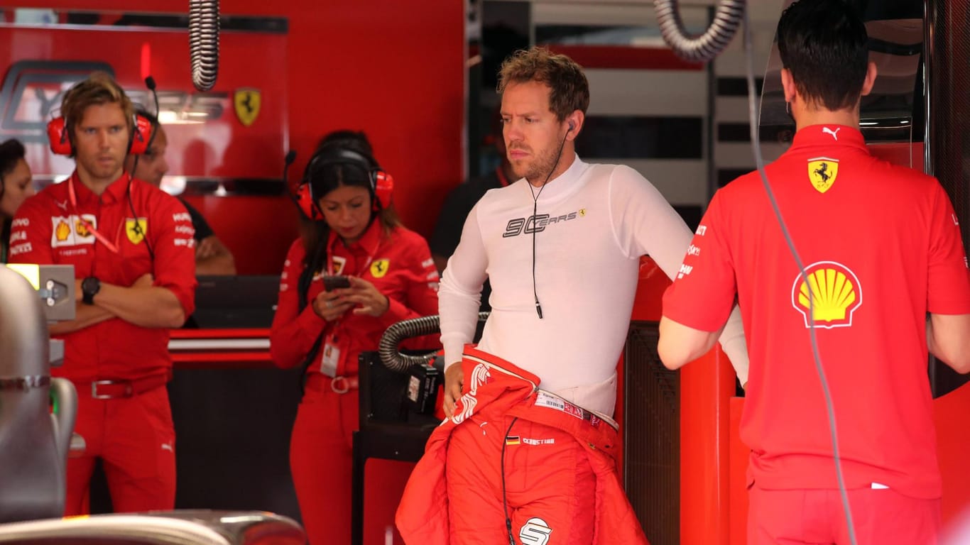 Sebastian Vettel (weiß) steht in der Box. Der Gesichtsausdruck spricht für sich.