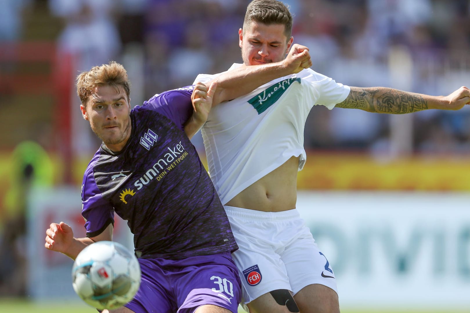 Osnabrücks Benjamin Girth (l) im Kampf um den Ball mit Heidenheims.