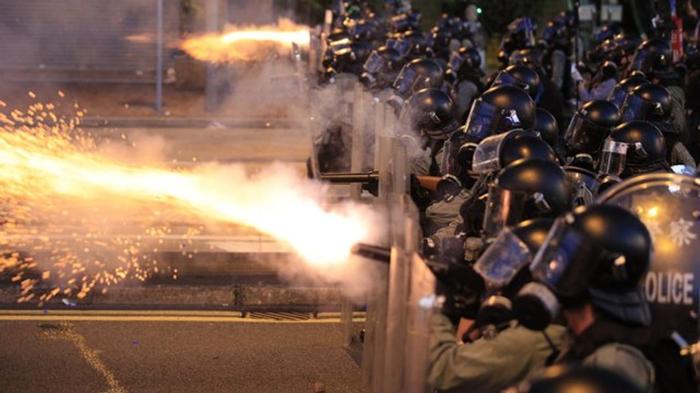 Die Polizei von Hongkong feuert Tränengas auf Demonstranten.