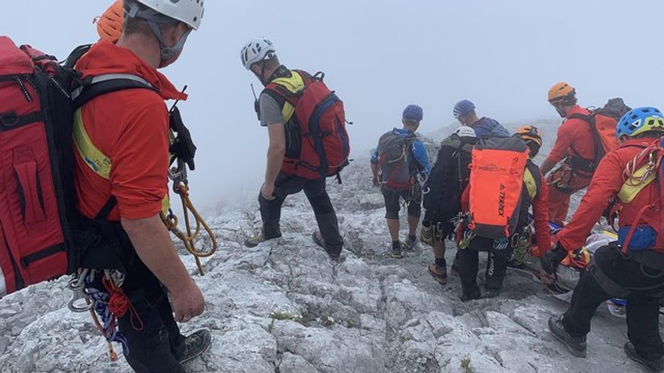 Bergretter transportieren die abgestürzte Bergsteigerin auf einer Trage den nebligen Berg hinunter: Der Nebel macht die Rettungsaktion extrem schwierig.