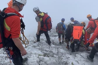 Bergretter transportieren die abgestürzte Bergsteigerin auf einer Trage den nebligen Berg hinunter: Der Nebel macht die Rettungsaktion extrem schwierig.