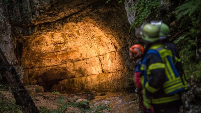 Einsatzkräfte stehen am Eingang der Falkensteiner Höhle.