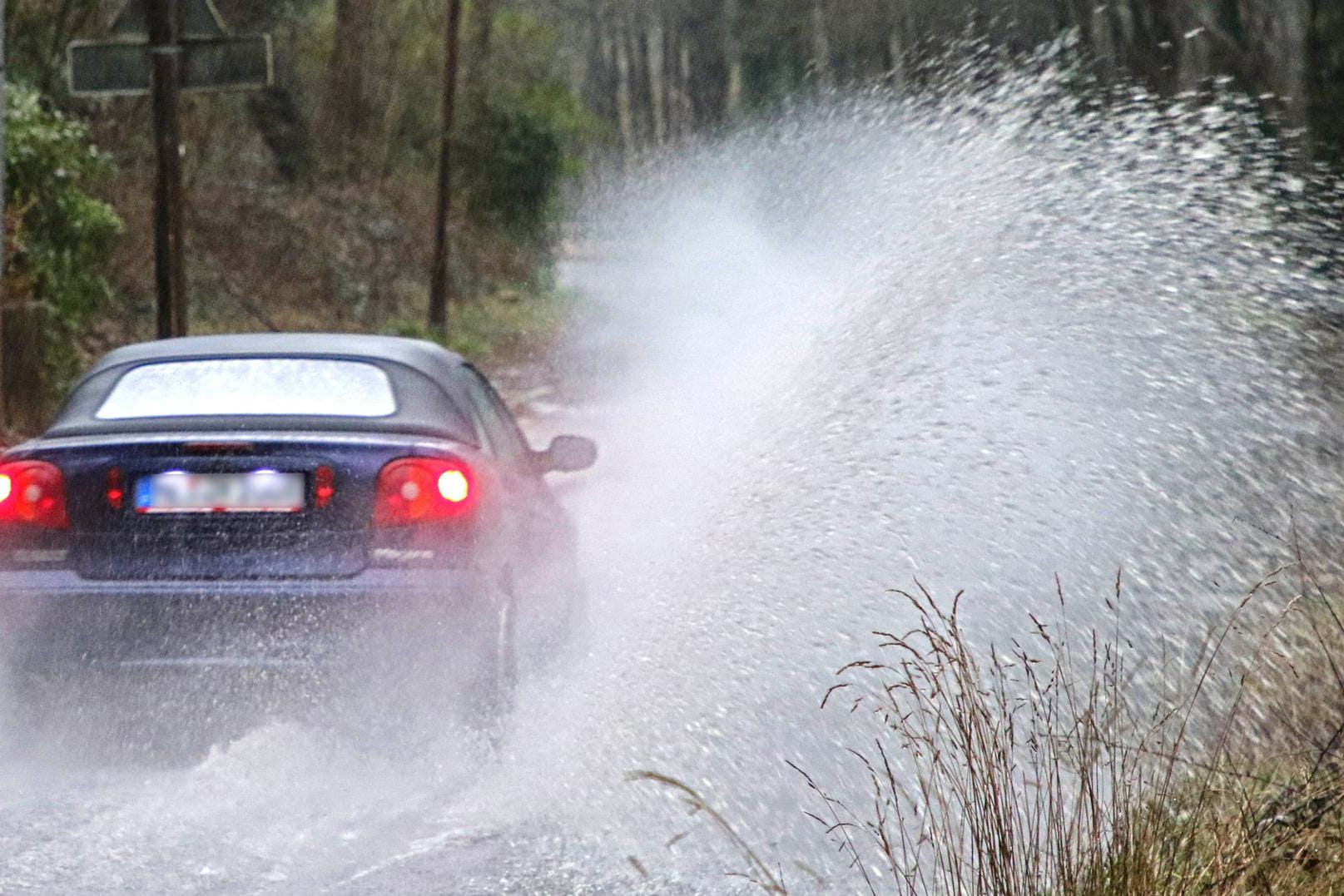 Starkregen auf einer Straße: Im ganzen Osten sowie in der Region München wird am Montag vor heftigen Regenfällen gewarnt.