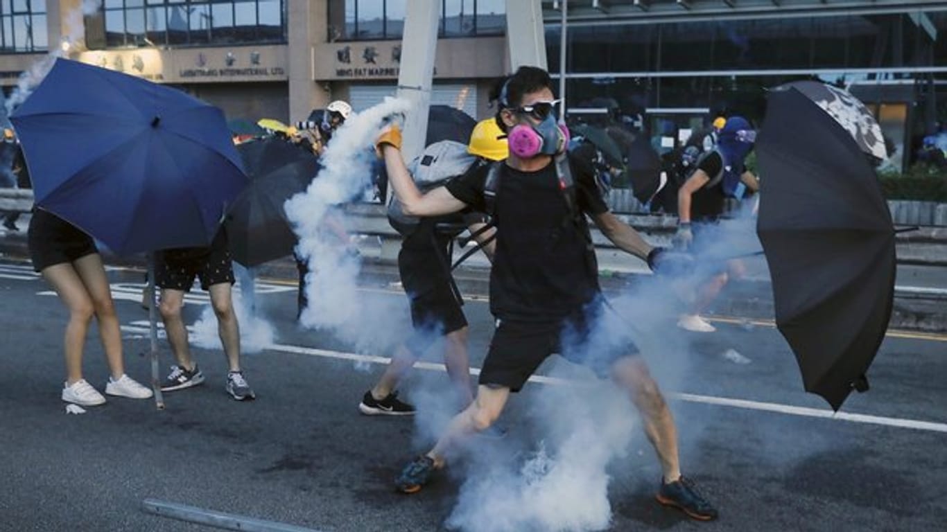 Ein Demonstrant wirft einen Tränengasbehälter, der von der Polizei abgefeuert wurde.