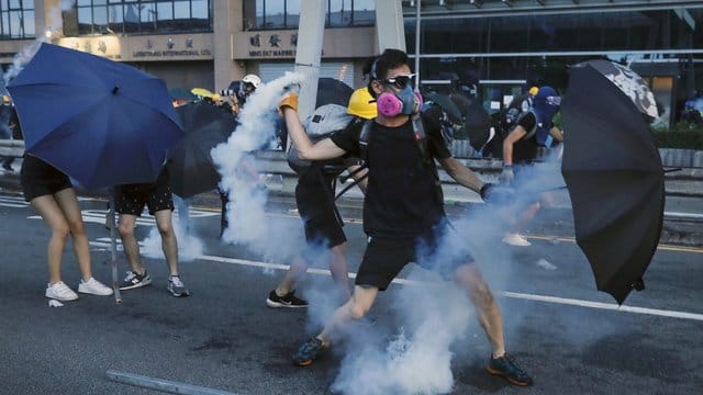Ein Demonstrant wirft einen Tränengasbehälter, der von der Polizei abgefeuert wurde. Ein Demonstrant wirft einen Tränengasbehälter, der von der Polizei abgefeuert wurde.