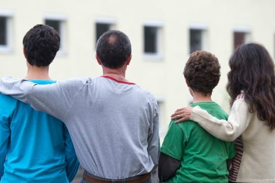 Eine syrische Familie sitzt vor einem Asylwohnheim der Zentralen Ausländerbehörde des Landes Brandenburg.