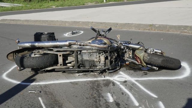 Ein Motorrad liegt nach einem Unfall auf der Straße. Ein Motorrad liegt nach einem Unfall auf der Straße.