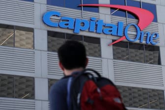 Ein Mann mit Rucksack steht vor einer Filiale der US-Bank Capital One: Bei einem Hackerangriff wurden die Daten von rund 100 Millionen Kunden kopiert.