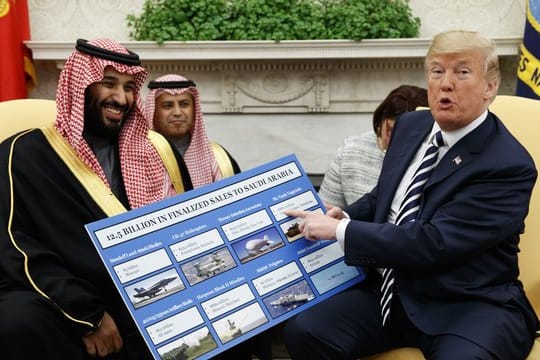US-Präsident Donald Trump (r) empfängt den saudischen Kronprinzen Mohammed bin Salman 2018 im Weißen Haus und zeigt dabei auf ein Plakat, auf dem die Waffenverkäufe von den USA an Saudi-Arabien detailliert erklärt sind.