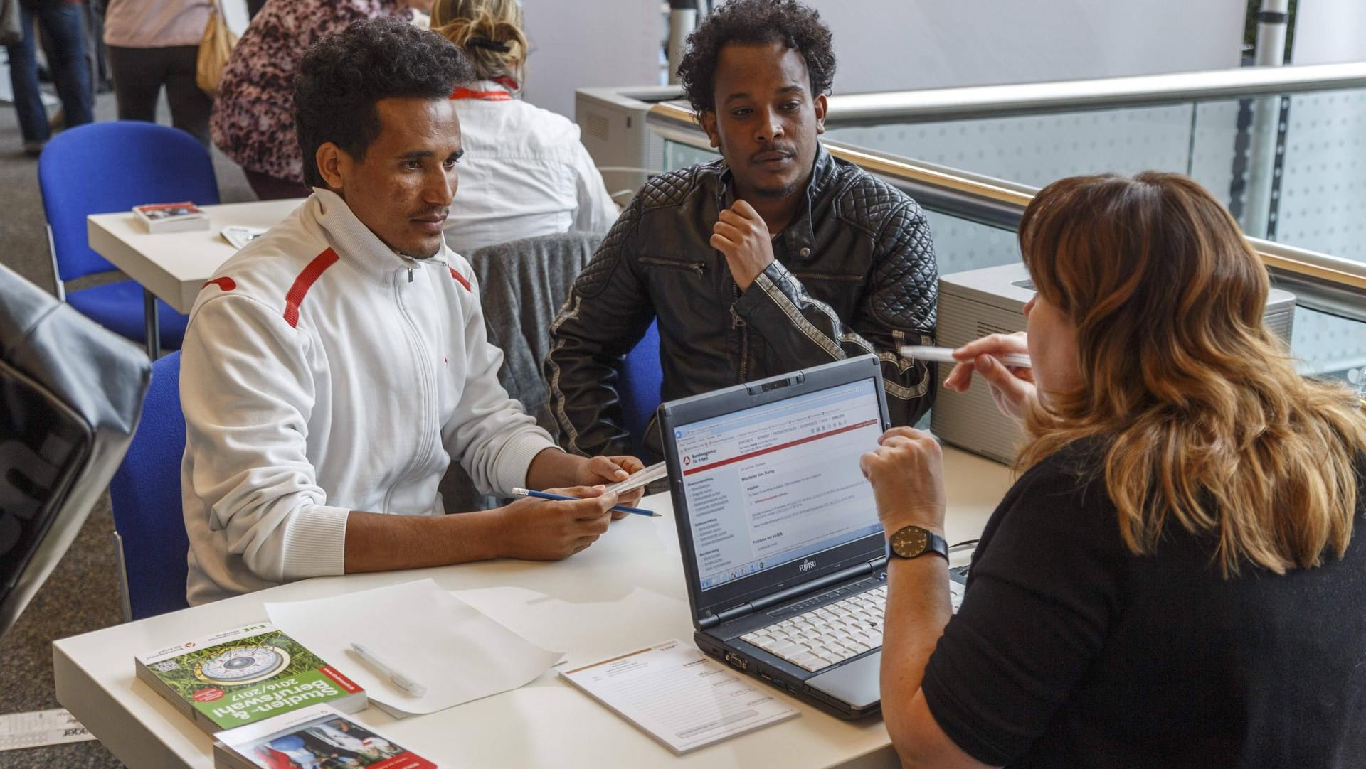 Zwei junge Männer aus Eritrea auf einer Jobbörse in Cottbus: Knapp die Hälfte der Neuankömmlinge auf dem Arbeitsmarkt gehen einer Helfertätigkeit nach. (Symbolfoto)