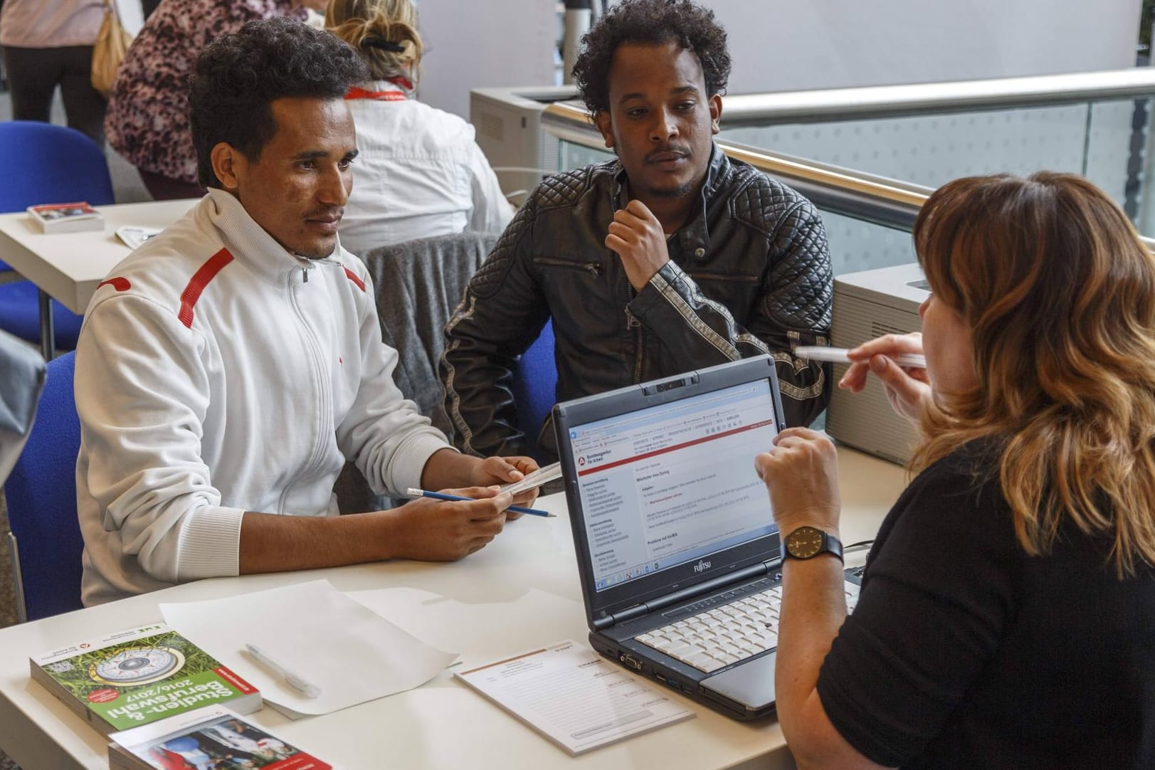 Zwei junge Männer aus Eritrea auf einer Jobbörse in Cottbus: Knapp die Hälfte der Neuankömmlinge auf dem Arbeitsmarkt gehen einer Helfertätigkeit nach. (Symbolfoto)