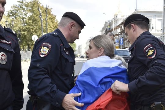 Russische Polizeibeamte verhaften eine Oppositionelle bei der nicht genehmigten Kundgebung im Zentrum der Stadt.