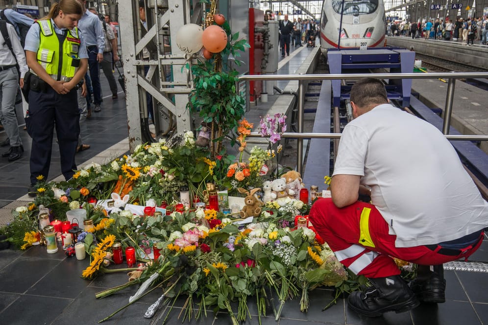 Ein Ersthelfer legt am Bahnsteig 7 im Frankfurter Hauptbahnhof Blumen nieder: Ein achtjähriger Junge wurde am Dienstag vor einen einfahrenden ICE gestoßen und starb.