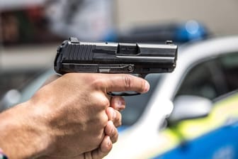 Ein Polizist zückt eine Waffe: In Bremen musste die Polizei mit einem Großaufgebot ausrücken. (Symbolbild)