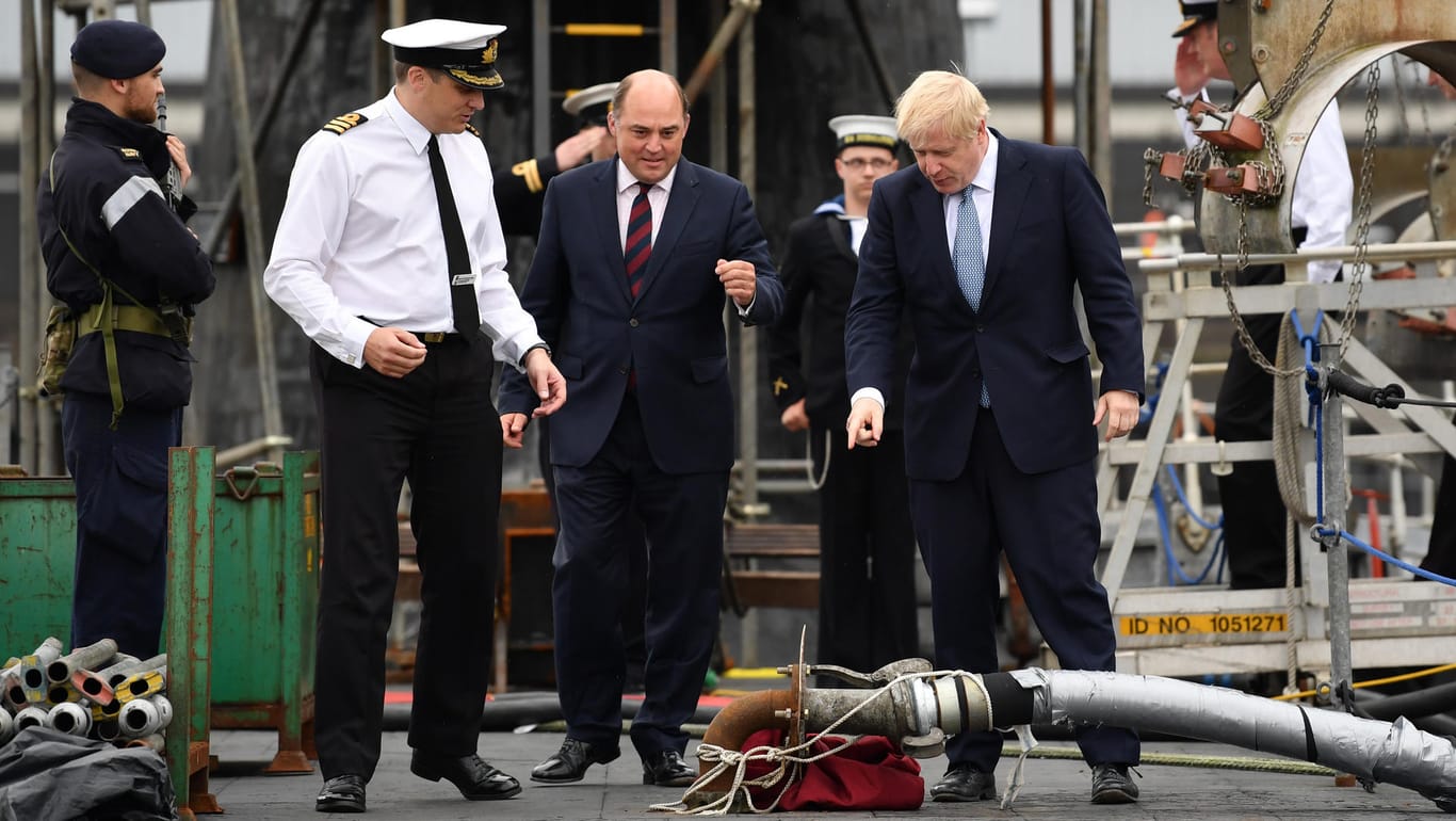 Im Feuer der Kritik: Premier Boris Johnson (re.), hier mit Verteidigungsminister Ben Wallace (Mitte) und dem Kommandeur Justin Codd beim Besuch des U-Boots HMS Victorious auf der Marine-Basis Faslane in Schottland.
