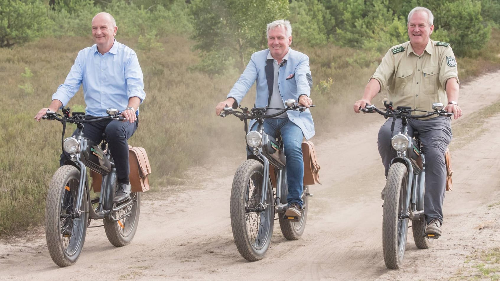 Brandenburgs Ministerpräsident Dietmar Woidke (l.) fährt mit dem Rad durch Sielmanns Naturlandschaft Kyritz-Ruppiner Heide.