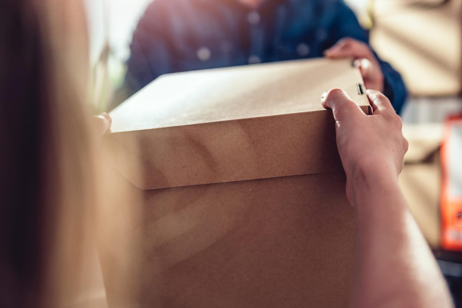 Ein Paket wird übergeben: Wer Produkte aus Fernost bestellt, sollte einiges beachten. (Symbolbild)
