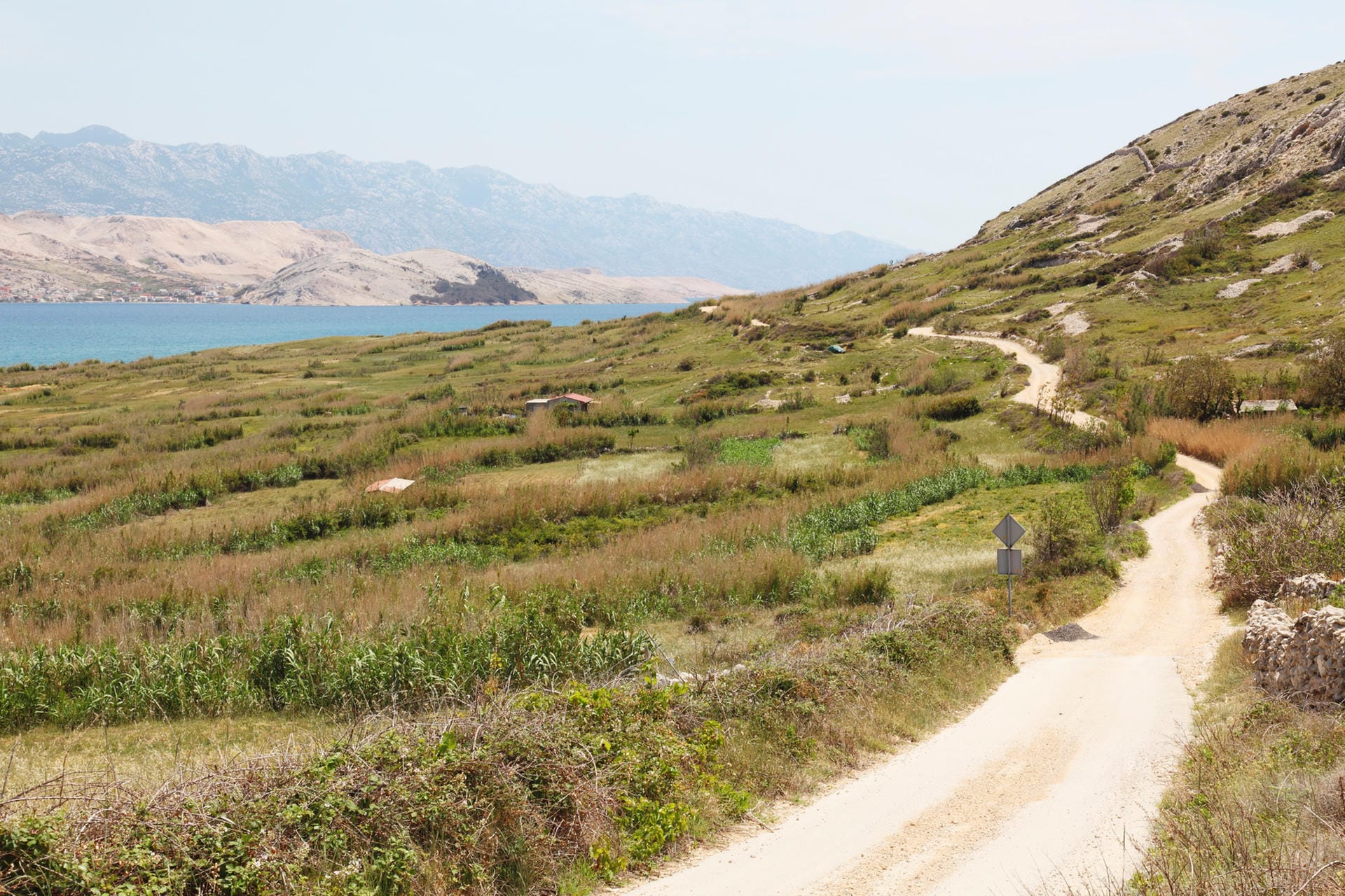 Feldweg bei Rab in Kroatien: Wenn Sie Wege durch die grünen Hügel wählen, ist oft das Meer mit einer erfrischenden Brise nicht weit entfernt.