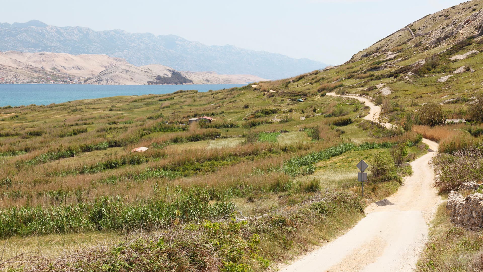 Feldweg bei Rab in Kroatien: Wenn Sie Wege durch die grünen Hügel wählen, ist oft das Meer mit einer erfrischenden Brise nicht weit entfernt.