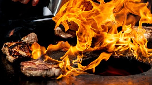 Auf einem Feuergrill wird der Nacken vom Iberico-Schwein gegrillt.