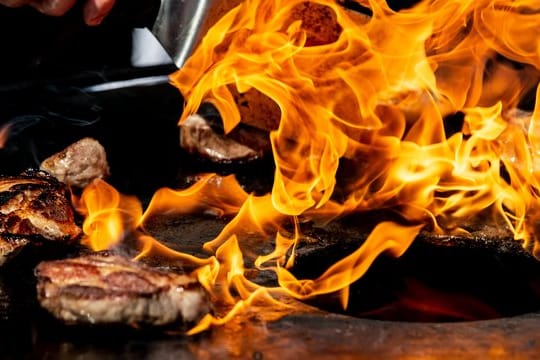 Auf einem Feuergrill wird der Nacken vom Iberico-Schwein gegrillt.