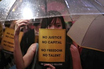 Hongkong: Eine Frau mit Regenschirm hält während einer Demonstration im Chater Garden ein Schild mit der Aufschrift «No Justice No Capital No Freedom No Talent» in der Hand.