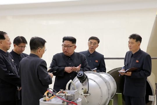 Nordkoreas Staatschef Kim Jong Un neben einem Sprengkopf.