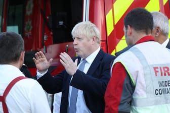 Der britische Premierminister Boris Johnson spricht während seines Besuchs in Whaley Bridge mit Einsatzkräften.