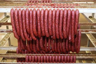 Frische Würste hängen in einer Fabrik: Bei der Firma Metten Fleischwaren wurden Kunststoffteile in den Cabanossi gefunden. (Symbolbild)