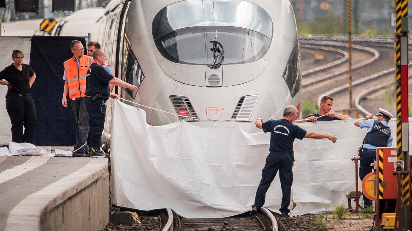Frankfurt: Polizisten und Feuerwehrleute spannen im Hauptbahnhof eine weiße Plane als Sichtschutz vor einen ICE. Ein achtjähriger Junge ist im Frankfurter Hauptbahnhof von einem Mann vor den einfahrenden ICE gestoßen und getötet worden.
