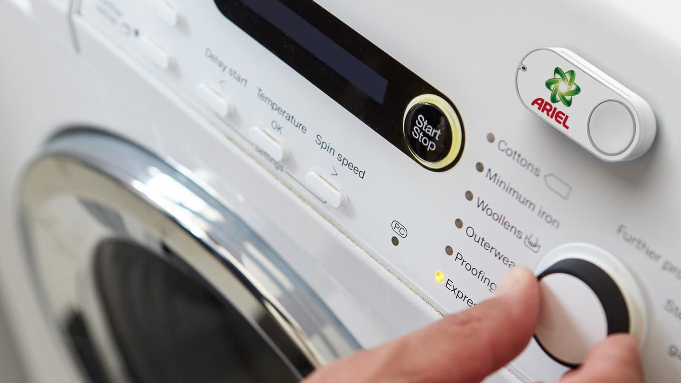 Ein Amazon Dash Button für die Marke Ariel, der an einer Waschmaschine klebt: Amazon klemmt die Bestellknöpfe bald ab.