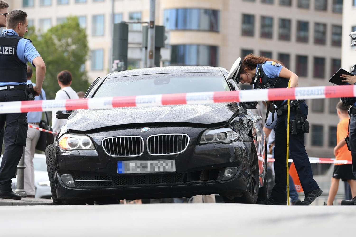 Polizeibeamte stehen am Frankfurter Hauptbahnhof an einem schwarzen BMW, mit dem mehrere Täter nach einem Raubüberfall geflüchtet waren.