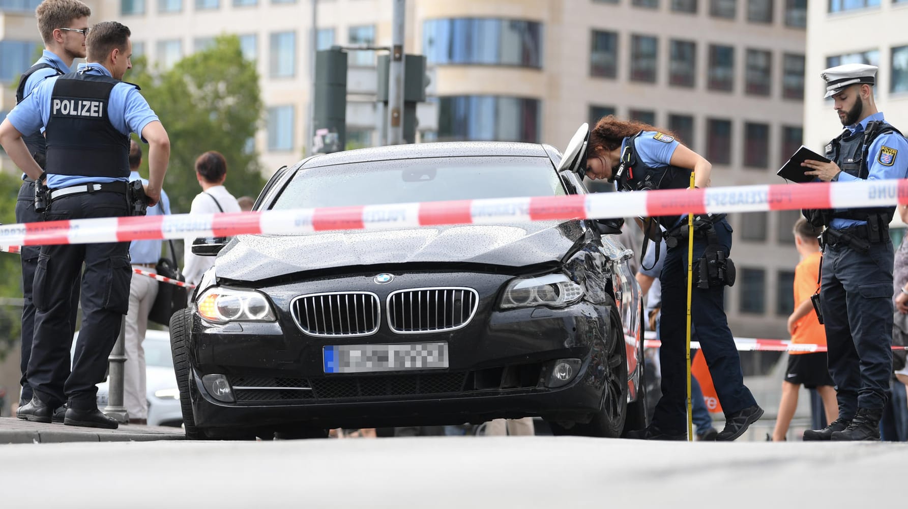 Polizeibeamte stehen am Frankfurter Hauptbahnhof an einem schwarzen BMW, mit dem mehrere Täter nach einem Raubüberfall geflüchtet waren.