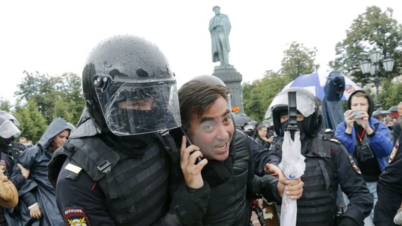 Polizisten führen Demonstranten ab.