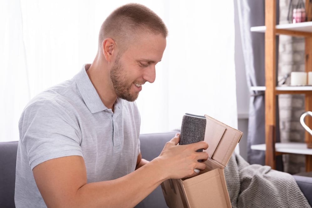 Ein Mann nimmt eine Bluetooth-Box aus einem Karton: Nicht jeder Versandhändler geht seiner Pflicht nach, Elektrogeräte zurück zu nehmen.