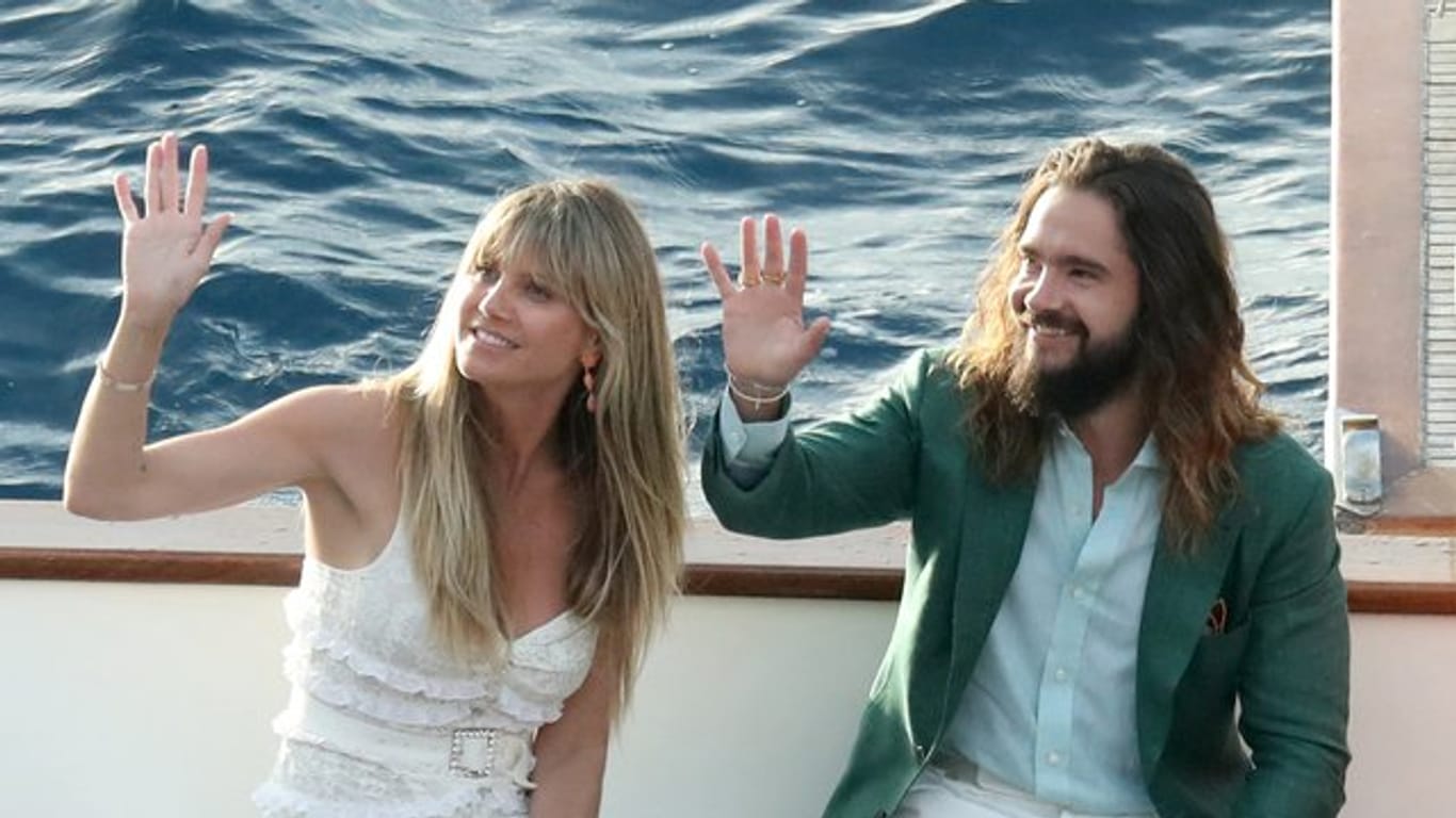 Topmodel Heidi Klum und Musiker Tom Kaulitz winken von einem Boot.