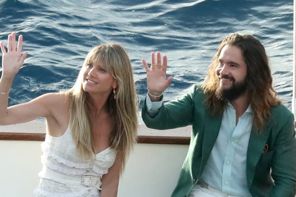 Topmodel Heidi Klum und Musiker Tom Kaulitz winken von einem Boot.