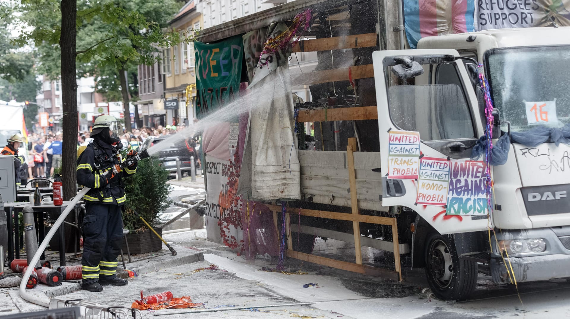 Ein Feuerwehrmann löscht den brennenden Wagen beim Hamburger CSD: Die Parade wurde wegen des Einsatzes unterbrochen, konnte dann aber fortgesetzt werden. Ein Feuerwehrmann löscht den brennenden Wagen beim Hamburger CSD: Die Parade wurde wegen des Einsatzes unterbrochen, konnte dann aber fortgesetzt werden.