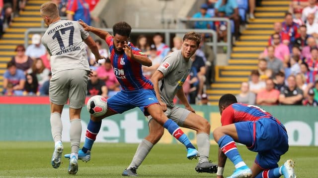 Crystal Palace Andros Townsend (M) im Zweikampf mit Herthas Maximilian Mittelstadt (l) und Niklas Stark (r).