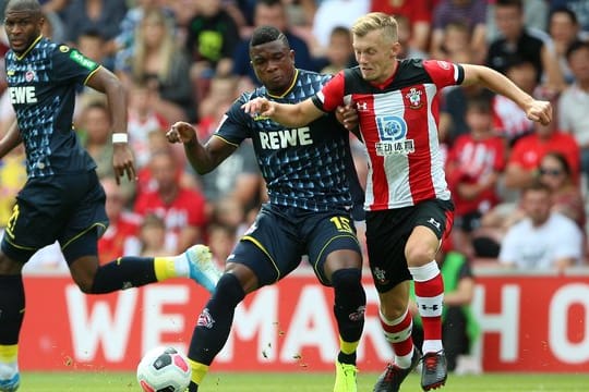 Kölns Jhon Cordoba (M) versucht den Ball vor Southamptons James Ward-Prowse (r) abzuschirmen.