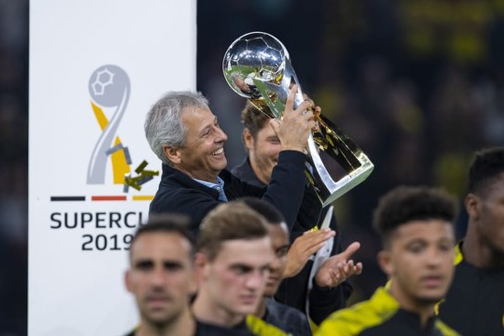Trägt nach der Siegerehrung den Pokal eigenhändig vom Podest: Dortmunds Trainer Lucien Favre mit Supercup.
