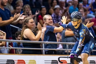 Bahnradfahrerin Lea Sophie Friedrich jubelt mit Zuschauern über ihren Sieg.