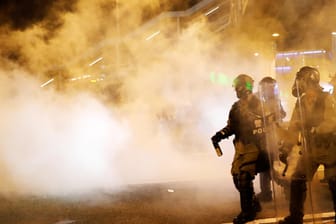 Polizisten feuern während einer der Demonstrationen Tränengas ab: Wiederholt kommt es in Hongkong zu schweren Zusammenstößen zwischen Demonstranten und der Polizei.