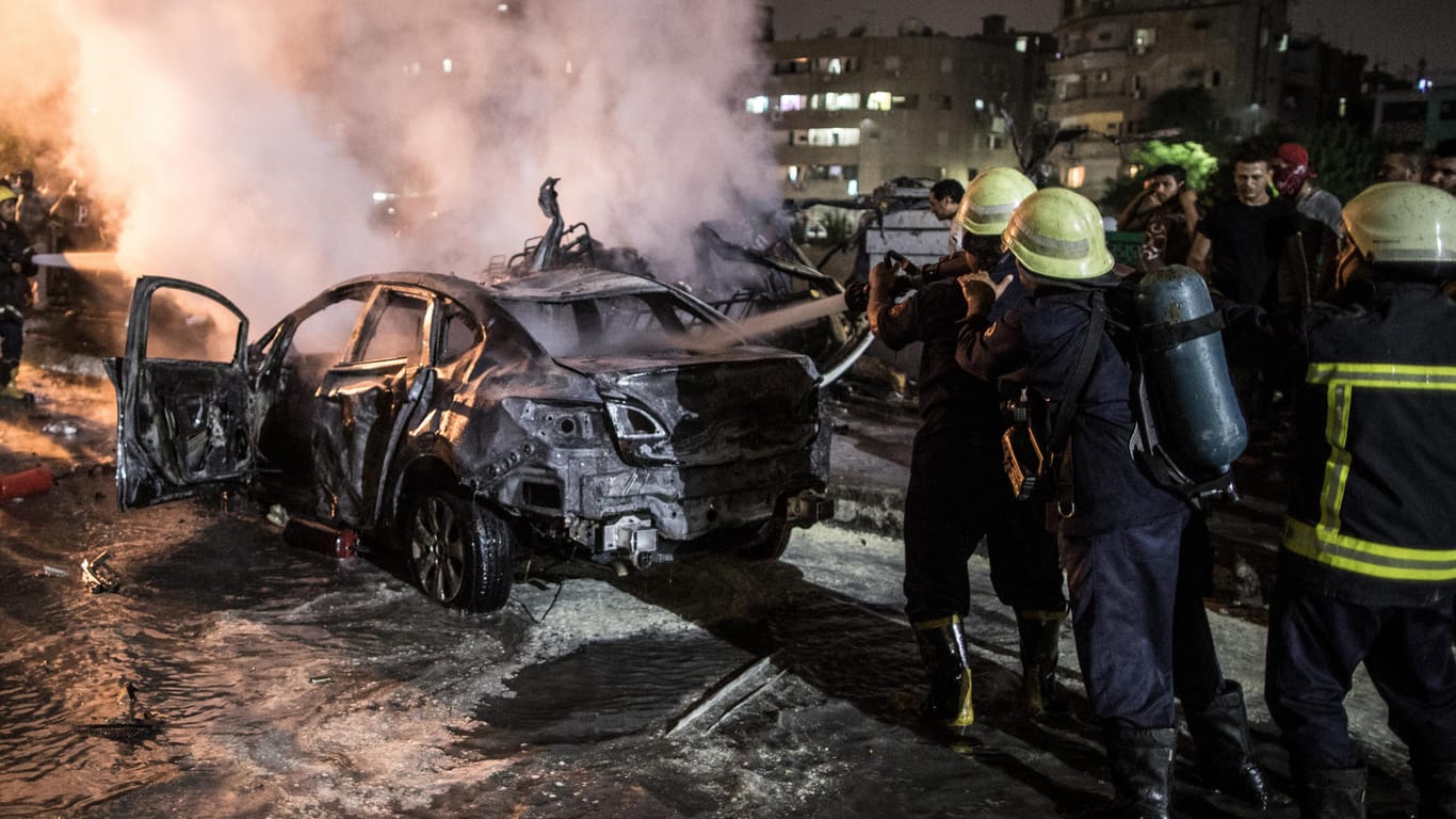 Feuerwehrmänner löschen ein brennendes Auto nach einer Explosion in der Nähe des Krebsforschungsinstituts. Bei einer Explosion in der Innenstadt Kairos sind nach offiziellen Angaben mindestens 19 Menschen getötet und 21 weitere verletzt worden.