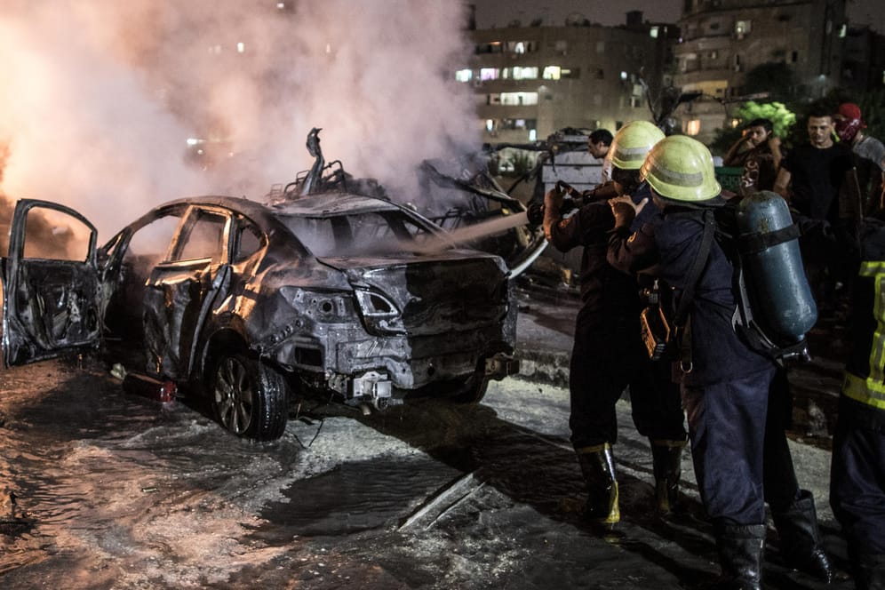 Feuerwehrmänner löschen ein brennendes Auto nach einer Explosion in der Nähe des Krebsforschungsinstituts. Bei einer Explosion in der Innenstadt Kairos sind nach offiziellen Angaben mindestens 19 Menschen getötet und 21 weitere verletzt worden.