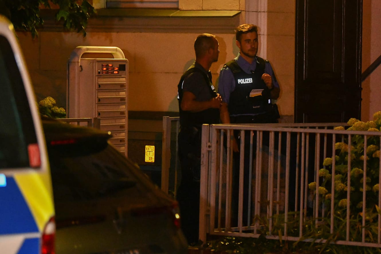 Polizisten vor dem Haus, in dem eine Frauenleiche gefunden wurde: Die Ermittler gehen von einem Tötungsdelikt aus. Nach dem Partner der jungen Frau wird gefahndet.