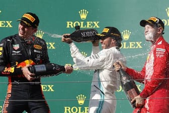 Champagnerdusche: Sieger Lewis Hamilton (M) mit Max Verstappen (l) und Sebastian Vettel auf dem Podium in Budapest.