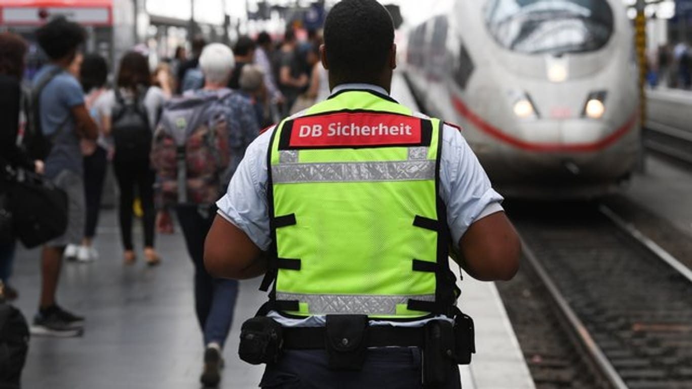 Ein Mitarbeiter der DB Sicherheit steht am Gleis 7 des Frankfurter Hauptbahnhofs, in den ein ICE einfährt.